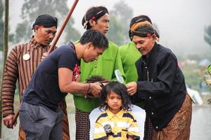 Dieng, Indonesia - August 1, 2015. Dieng Culture Festival, Tourists follow the dreadlocks procession during the Dieng Culture Festival event at Dieng, Banjarnegara district, Central Java photo