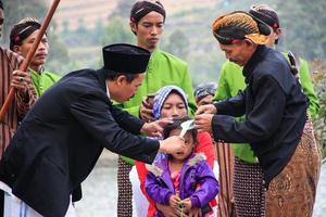 Dieng, Indonesia - August 1, 2015. Dieng Culture Festival, Tourists follow the dreadlocks procession during the Dieng Culture Festival event at Dieng, Banjarnegara district, Central Java photo