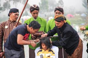 dieng, indonesia - 1 de agosto de 2015. festival cultural de dieng, los turistas siguen la procesión de rastas durante el evento del festival cultural de dieng en dieng, distrito de banjarnegara, java central foto