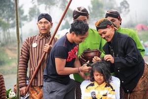 Dieng, Indonesia - August 1, 2015. Dieng Culture Festival, Tourists follow the dreadlocks procession during the Dieng Culture Festival event at Dieng, Banjarnegara district, Central Java photo