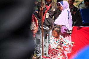 Dieng, Indonesia - August 1, 2015. Dieng Culture Festival, Tourists follow the dreadlocks procession during the Dieng Culture Festival event at Dieng, Banjarnegara district, Central Java photo