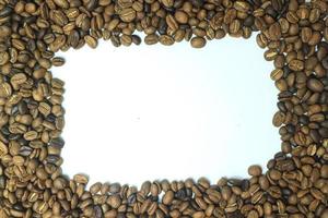 Frame made from roasted coffee beans over white background with room for text or image photo