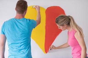 couple are painting a heart on the wall photo