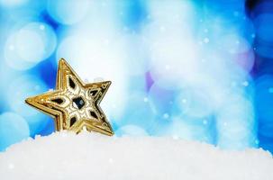 estrella y decoración navideña sobre fondo abstracto y copos de nieve foto
