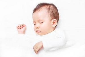 Newborn sleeping on the white bed photo