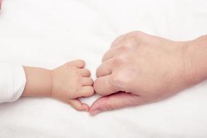 Close up of mother and babies hands touching with finger photo