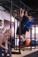 young athletes doing pull ups on the horizontal bar photo
