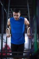 man working out pull ups with gymnastic rings photo