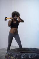 entrenamiento de mujer negra con martillo y neumático de tractor foto