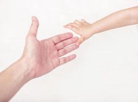 Close up of mother and babies hands touching with finger .Isolated on white. photo