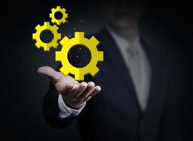 Close up of businessman holding gear mechanism in hand, business collection, studio shot photo