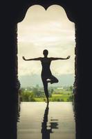 Silhouette of a beautiful Yoga woman in the morning - vintage style color effect photo