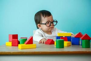 baby is playing with educational toys over blue background photo