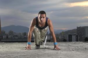 young man dancing and jumping  on top of the building photo