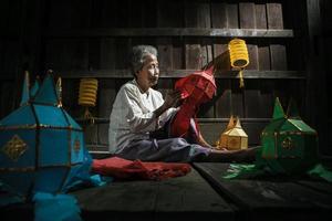 Thai old women made the lantern for yeepeng festival photo