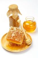 Honeycomb with jar and honey dipper isolated on white background photo