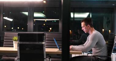 hombre trabajando en una laptop en una oficina oscura foto