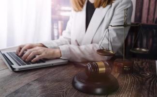 Business and lawyers discussing contract papers with brass scale on desk in office. Law, legal services, advice, justice and law concept picture with film grain effect photo