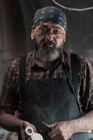 Spoon master in his workshop with wooden products and tools photo