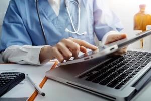 Medicine doctor and stethoscope touching icon medical network connection with modern interface on digital tablet in hospital background. Medical technology network concept photo