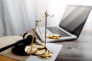 Business and lawyers discussing contract papers with brass scale on desk in office. Law, legal services, advice, justice and law concept picture with film grain effect photo