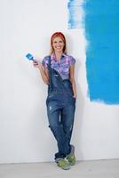 mujer sonriente feliz pintando el interior de la casa foto