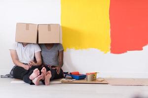 young multiethnic couple playing with cardboard boxes photo