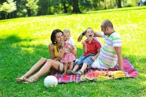 Feliz pareja joven con sus hijos divertirse en el parque foto