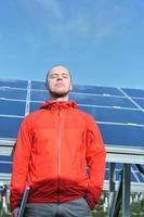 engineer using laptop at solar panels plant field photo