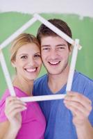 pareja feliz pintando una pared en su nuevo hogar foto