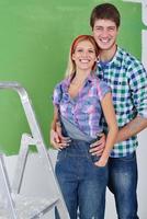 happy couple paint wall at new home photo