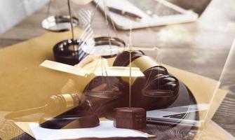 Business and lawyers discussing contract papers with brass scale on desk in office. Law, legal services, advice, justice and law concept picture with film grain effect photo