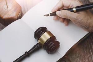 Business and lawyers discussing contract papers with brass scale on desk in office. Law, legal services, advice, justice and law concept picture with film grain effect photo