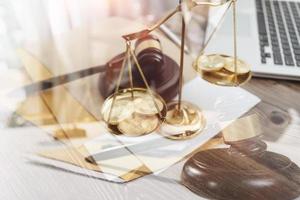 Justice and law concept.Male judge in a courtroom with the gavel, working with, computer and docking keyboard, eyeglasses, on table in morning light photo