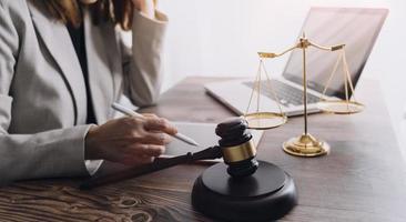 Business and lawyers discussing contract papers with brass scale on desk in office. Law, legal services, advice, justice and law concept picture with film grain effect photo