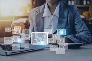 Big data analytics and business intelligence concept with chart and graph icons on a digital screen interface and a businessman hand in background photo