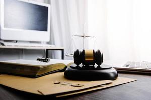 Business and lawyers discussing contract papers with brass scale on desk in office. Law, legal services, advice, justice and law concept picture with film grain effect photo