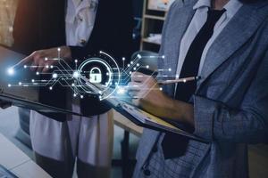 Cybersecurity and privacy concepts to protect data. Lock icon and internet network security technology. Businessman protecting personal data on smart phone with virtual screen interfaces. photo