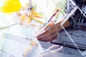 business hand working and laptop with on on architectural project at construction site at office desk in office photo