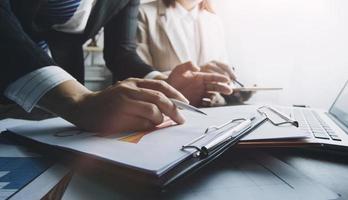 gente de negocios reunida para analizar y discutir y hacer una lluvia de ideas sobre los datos del gráfico del informe financiero en el trabajo en equipo del asesor financiero de la oficina y el concepto de contabilidad. foto