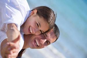 happy young couple have fun on beach photo