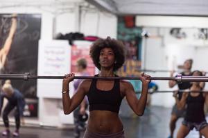 black woman lifting empty bar photo