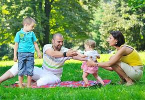 happy young couple with their children have fun at park photo