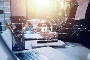 Cybersecurity and privacy concepts to protect data. Lock icon and internet network security technology. Businessman protecting personal data on smart phone with virtual screen interfaces. photo