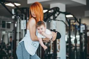 joven madre con su hijo pequeño en el gimnasio foto