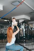 joven madre con su hijo pequeño en el gimnasio foto