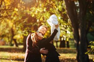 familia joven e hijo recién nacido en el parque de otoño foto