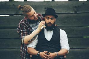 barbero afeita a un hombre barbudo foto