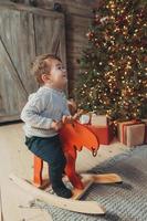 Shot of a cheerful kid riding on rocking horse photo