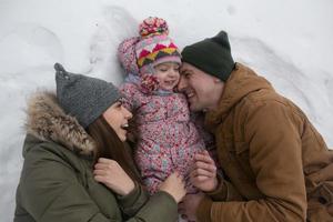 papá, mamá y su pequeña hija yacen en la nieve foto